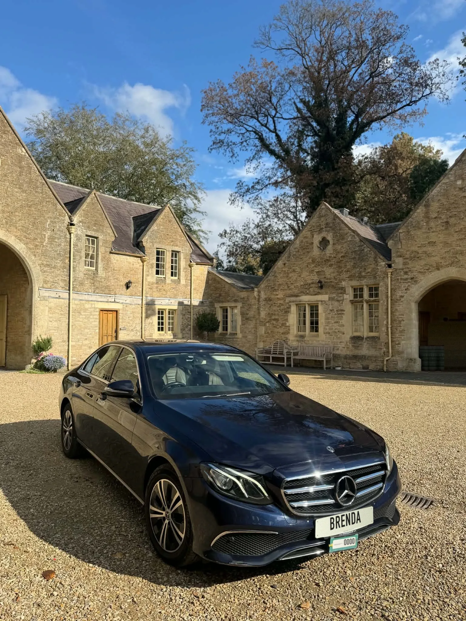 Brenda's dark blue Mercedes E-Class saloon in a stone courtyard.